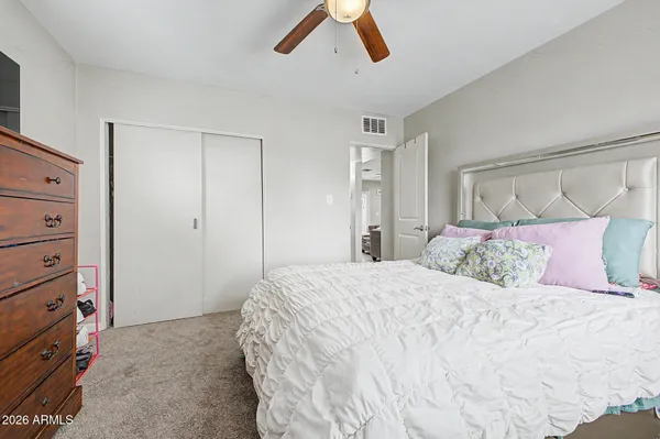 a bedroom with a large bed and a chandelier