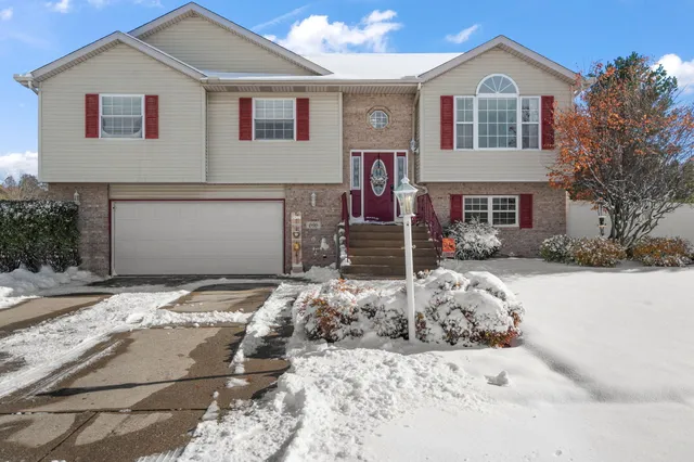 a view of a white house with a yard and large tree