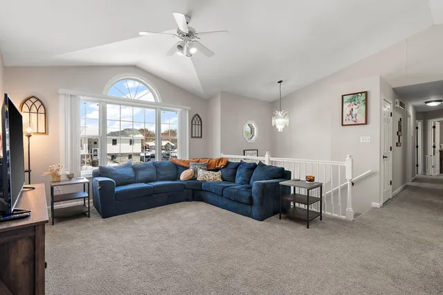 a living room with furniture a large window and a flat screen tv