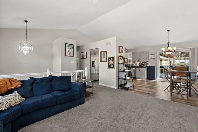 a living room with furniture and a dining table with kitchen view