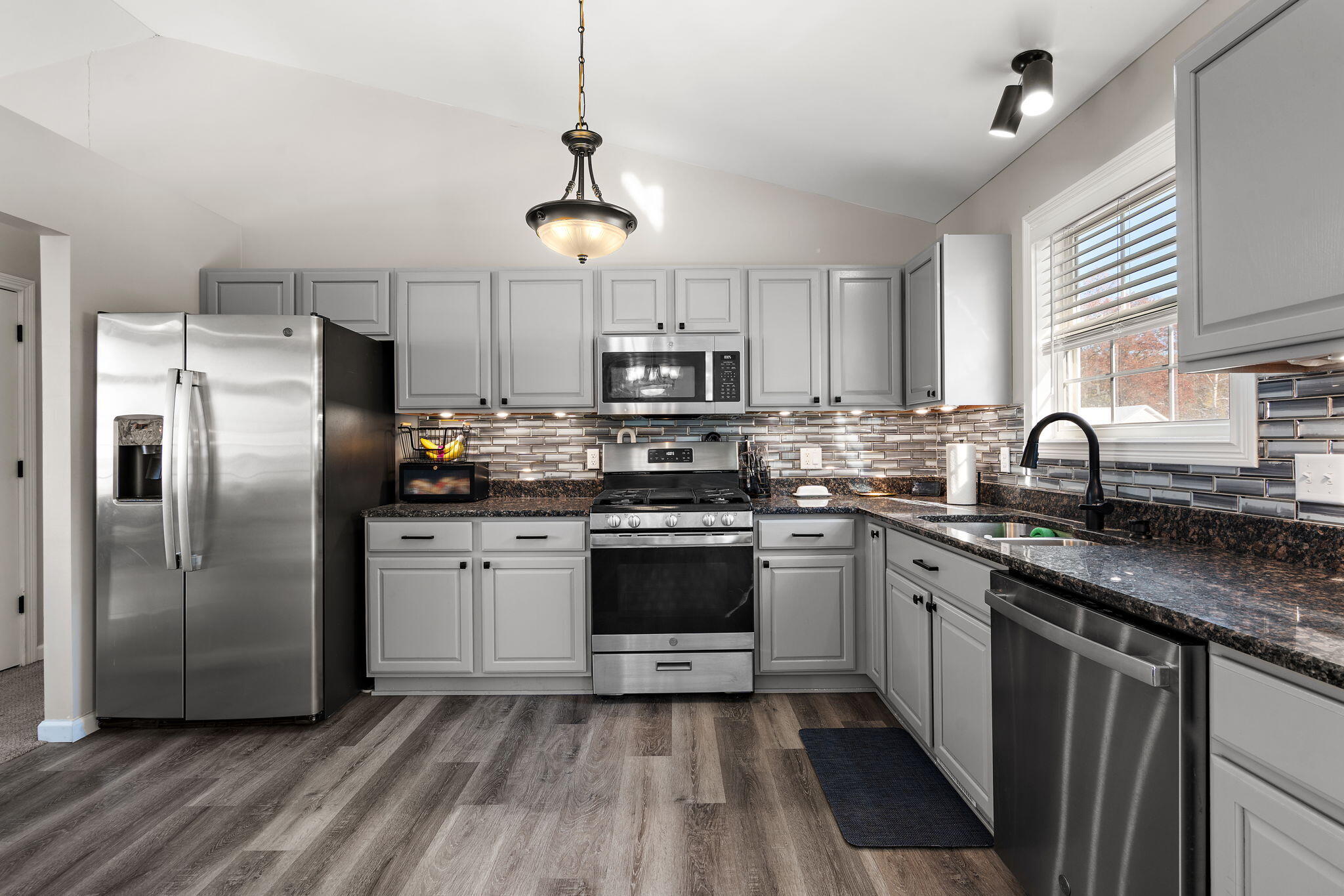 696 Admiral Drive Porter, IN 46304 - Photo 7 of 27 a kitchen with stainless steel appliances granite countertop a refrigerator a stove a sink dishwasher a microwave oven with a dining table and chairs