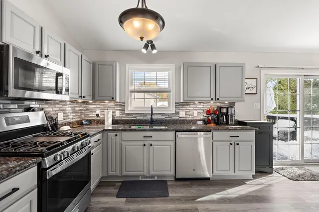 a kitchen with stainless steel appliances a sink stove and cabinets