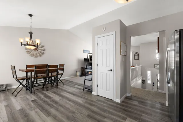 a view of a dining room and livingroom with furniture wooden floor a chandelier
