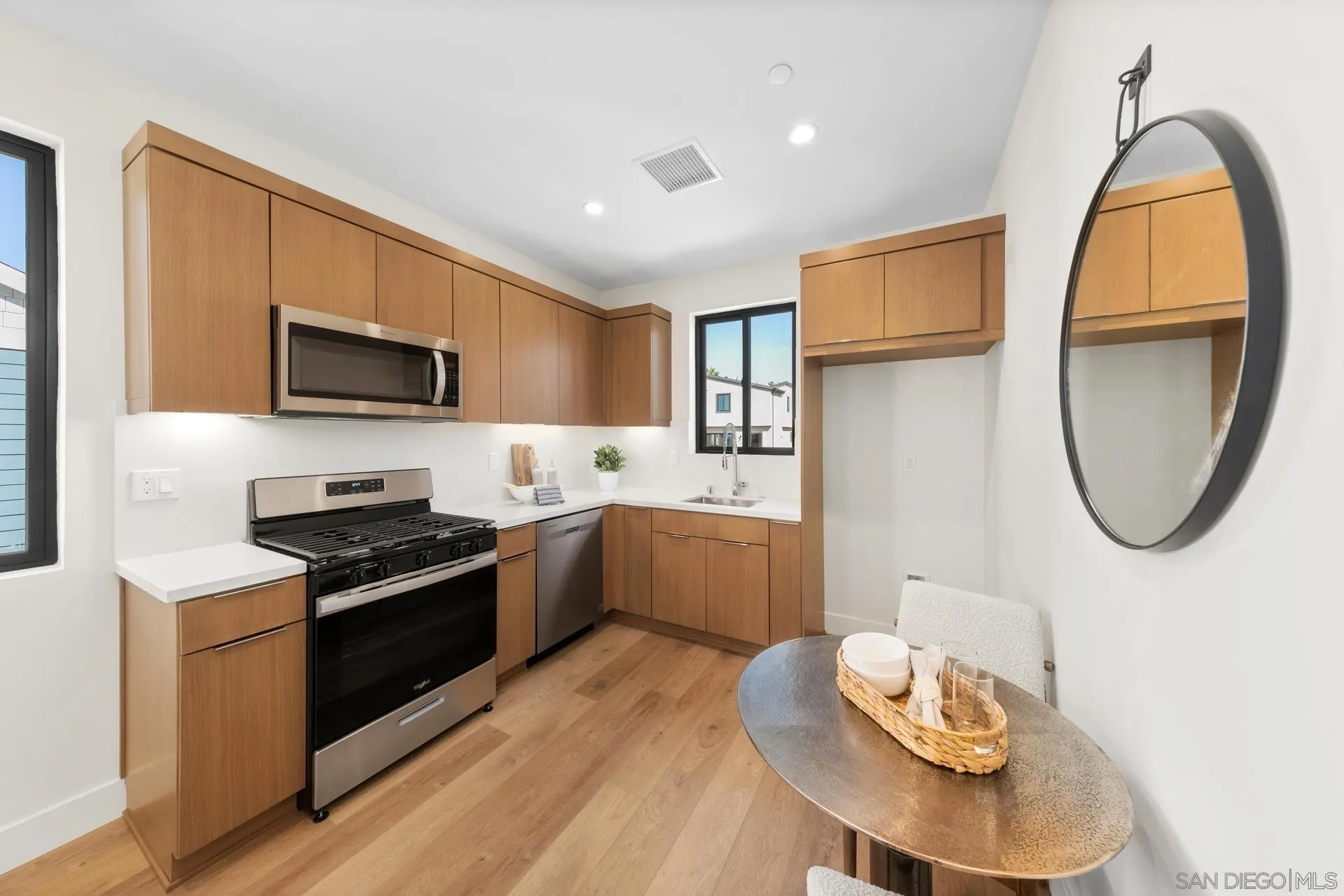1756 Whaley Street Oceanside, CA 92054 - Photo 37 of 47 a kitchen with stainless steel appliances a stove a sink a microwave a refrigerator and chairs