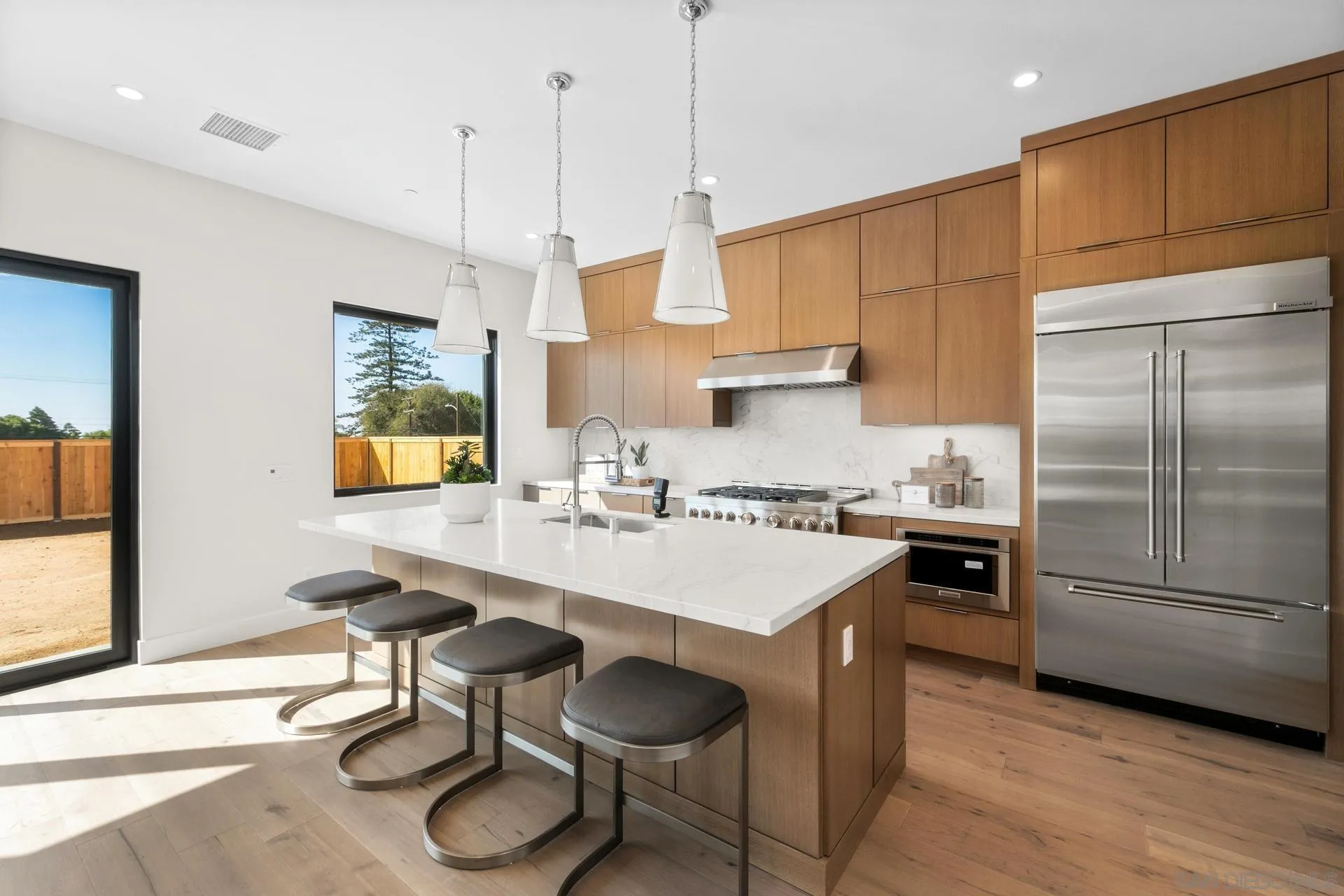 1756 Whaley Street Oceanside, CA 92054 - Photo 8 of 47 a kitchen with stainless steel appliances granite countertop a sink a stove a refrigerator and island with wooden floor