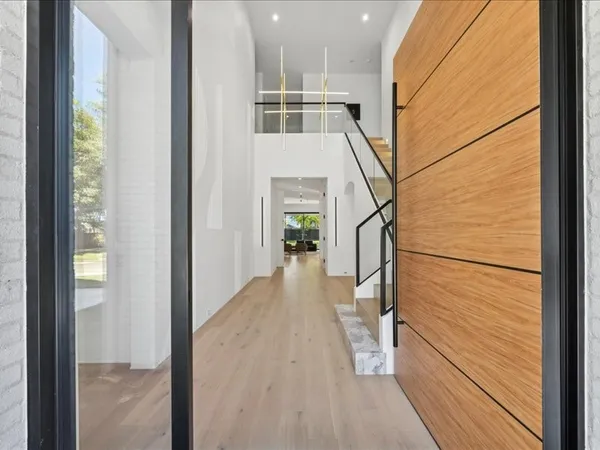 a view of a hallway with wooden floor and staircase