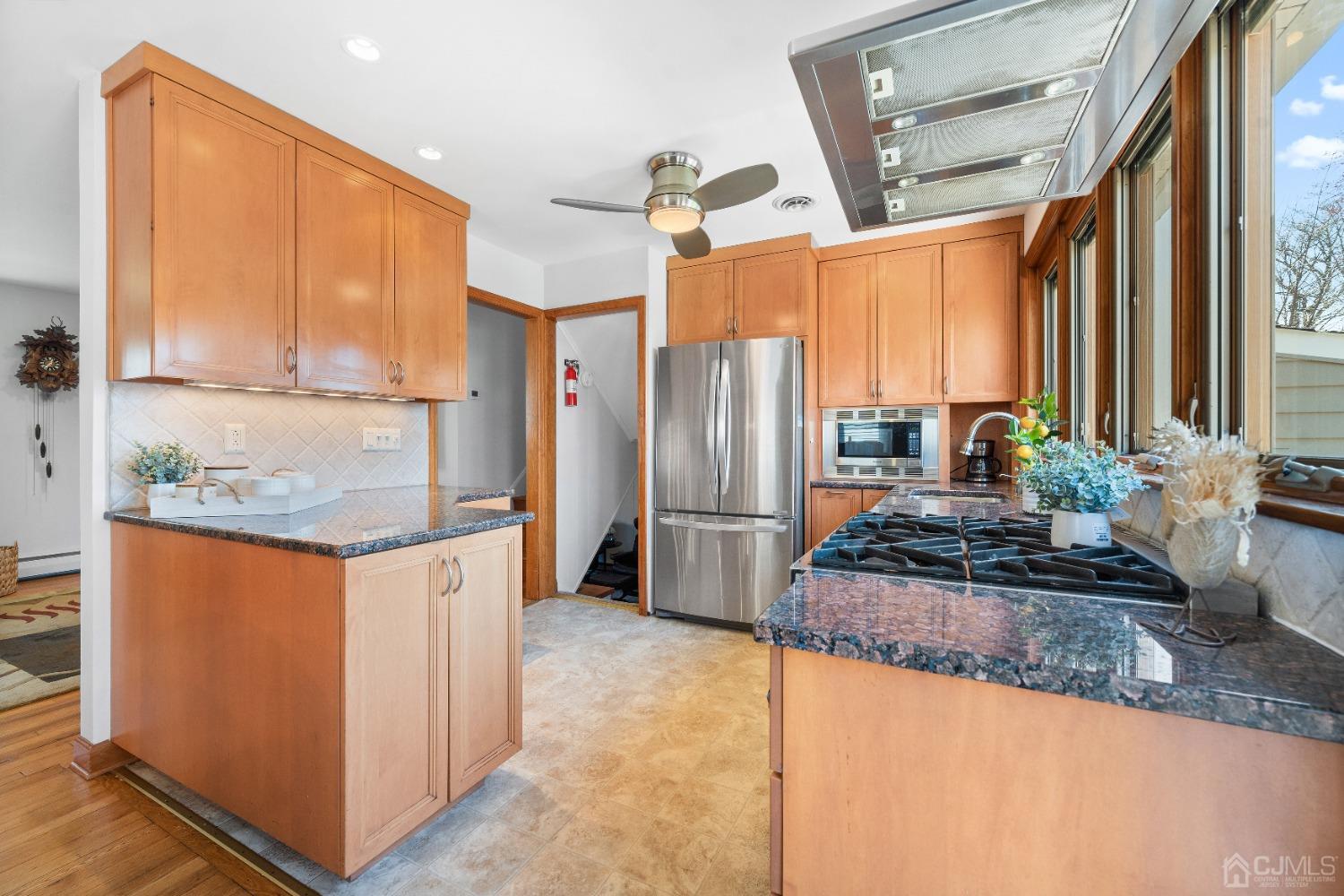 22 Baldwin Road Edison, NJ 08817 - Photo 5 of 30 a kitchen with stainless steel appliances granite countertop a refrigerator a stove and a sink with wooden floor