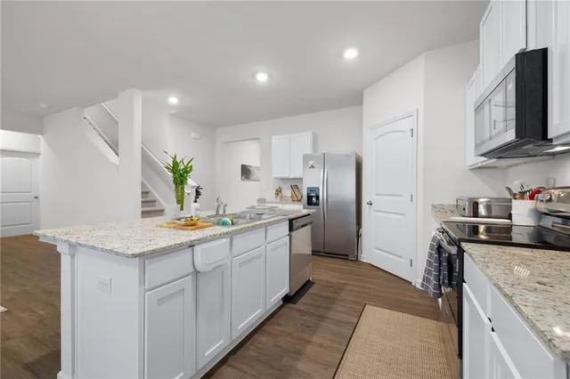 a kitchen with stainless steel appliances granite countertop a sink stove and refrigerator