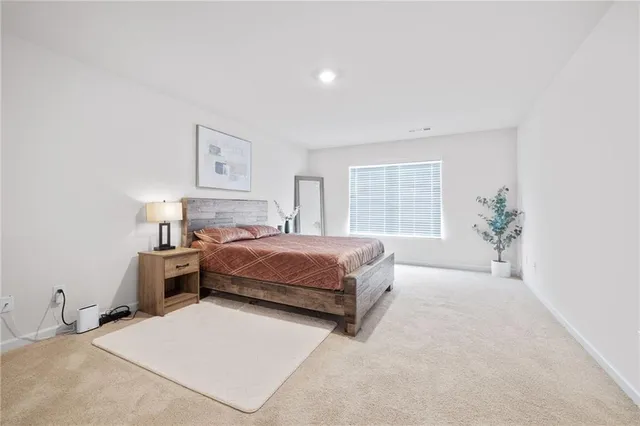 a bedroom with a large bed and a potted plant