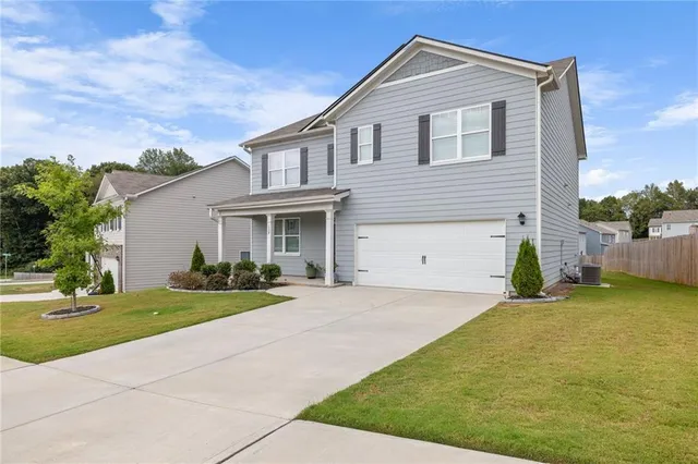 a front view of a house with a yard and garage
