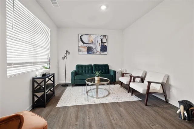 a living room with furniture and a wooden floor