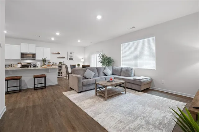 a living room with furniture and a wooden floor