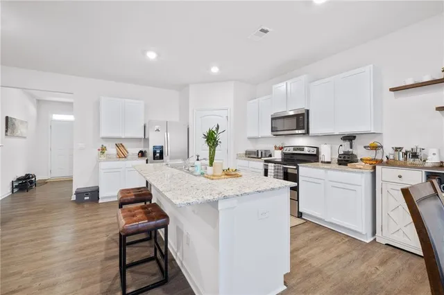 a kitchen with white cabinets and appliances
