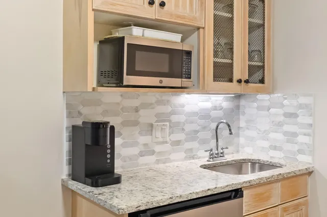 a kitchen with granite countertop a sink and a microwave