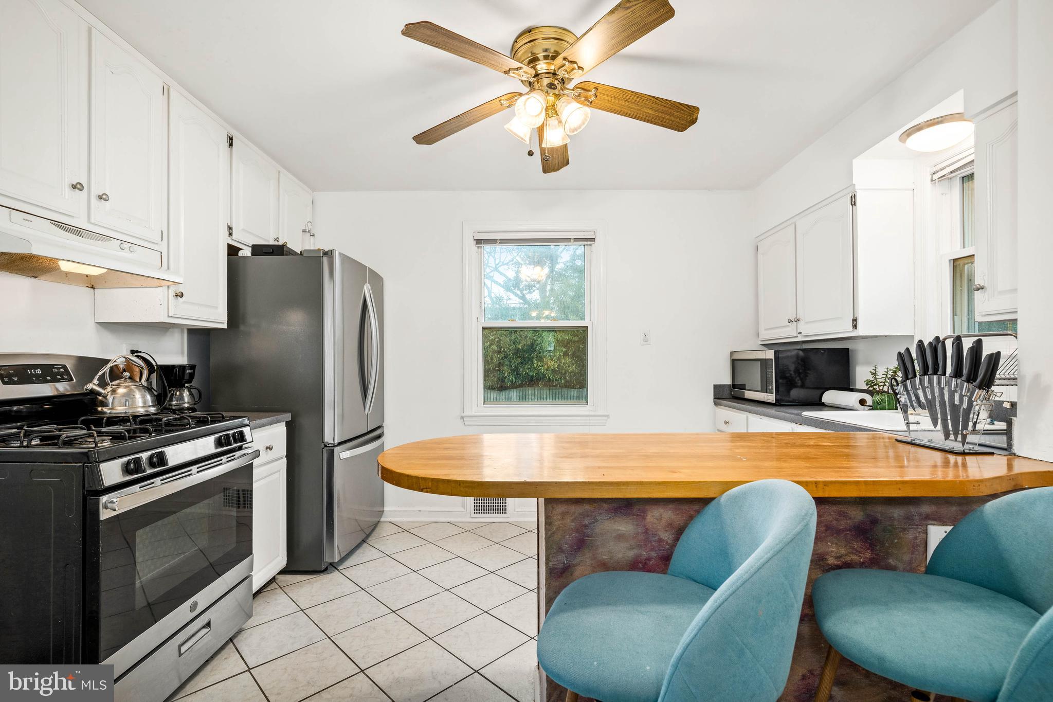 10149 Sutherland Road Silver Spring, MD 20901 - Photo 11 of 31 a kitchen with stainless steel appliances a table chairs and a refrigerator