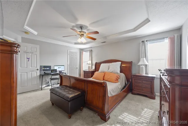 a bedroom with a large bed a chandelier and dresser