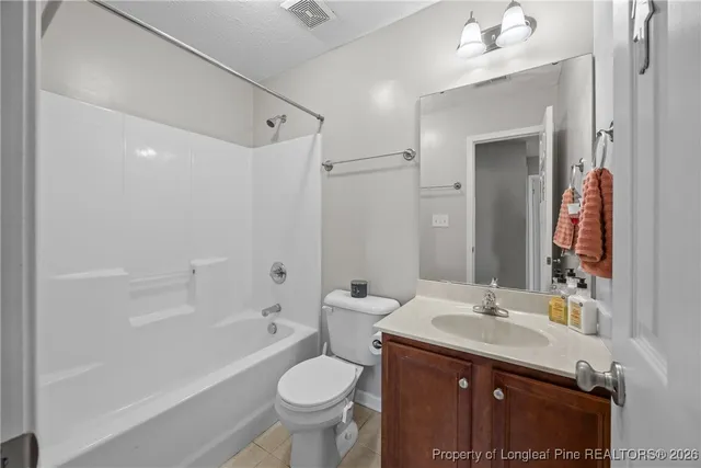 a bathroom with a bathtub shower sink vanity mirror and toilet