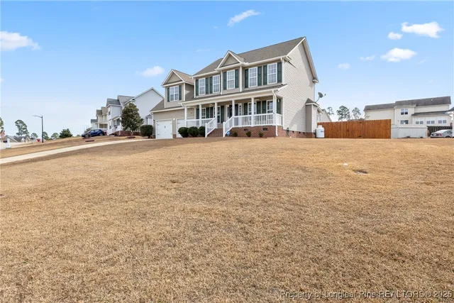 a front view of a building with a garden and balcony