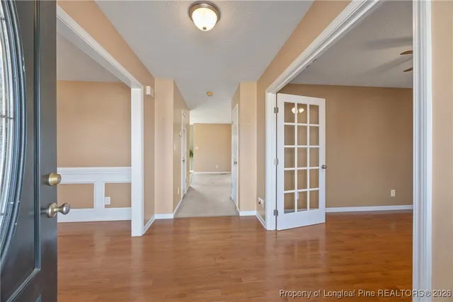 a view of a hallway with wooden floor and living room