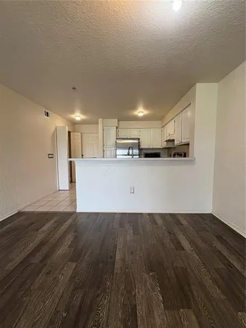 a view of a kitchen with wooden floor and electronic appliances