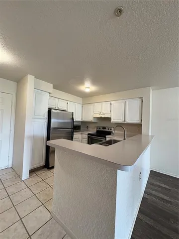 a kitchen with stainless steel appliances a refrigerator sink and microwave