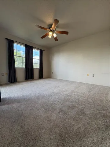 a view of a livingroom with a ceiling fan and window