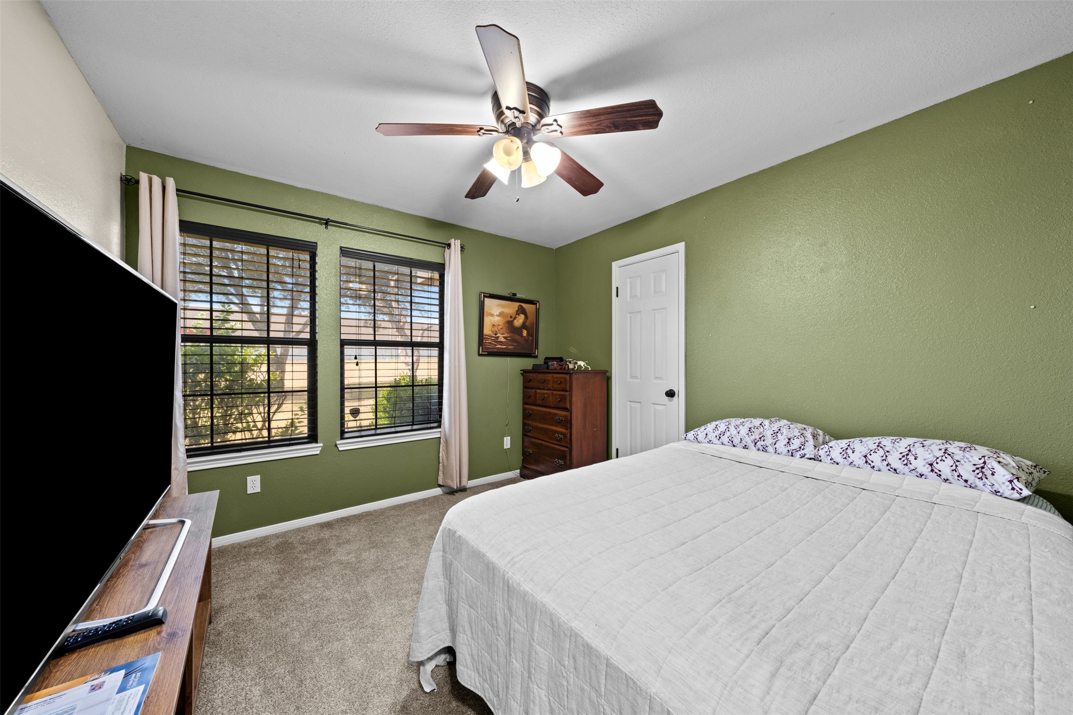 1512 Panther Loop Pflugerville, TX 78660 - Photo 11 of 40 A comfortable bedroom features plush carpeting and a cooling ceiling fan, perfect for restful nights.