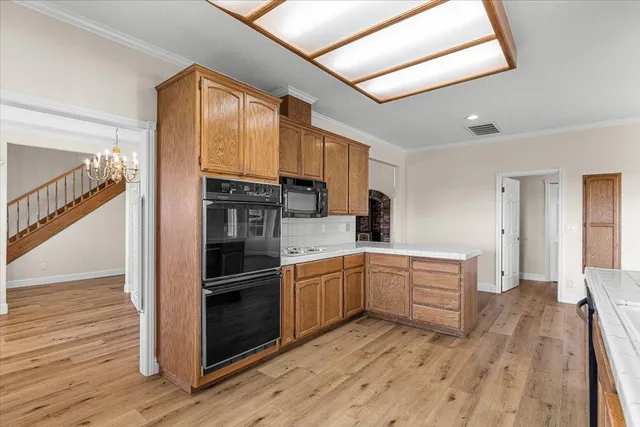 an empty room with wooden floor a fireplace and windows