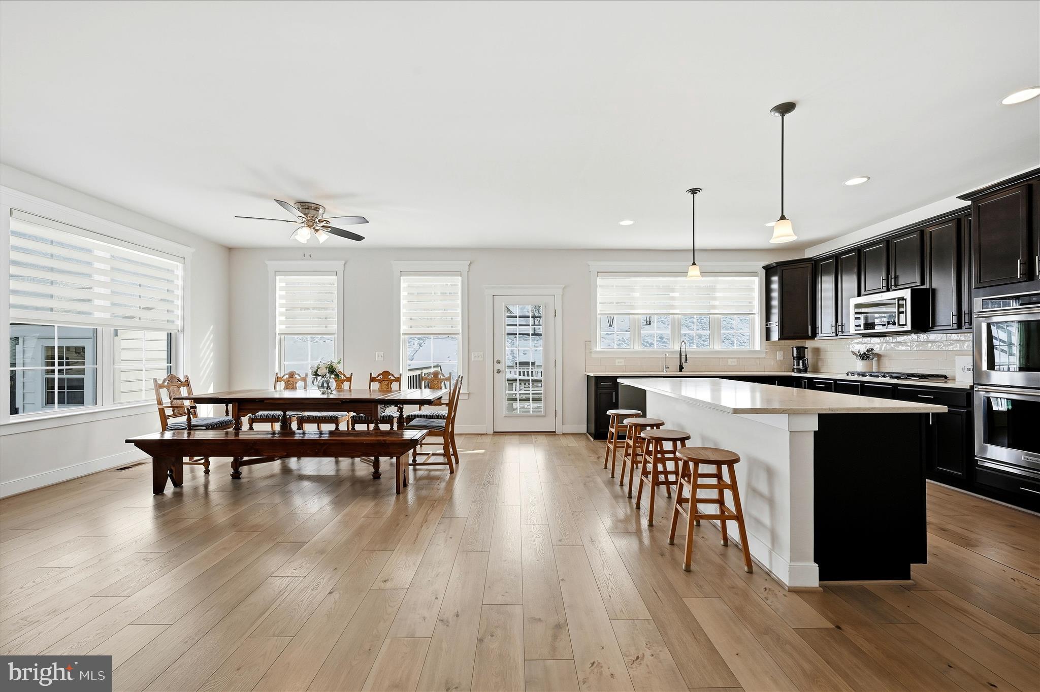 35939 Fieldside Way Round Hill, VA 20141 - Photo 20 of 82 a kitchen with stainless steel appliances granite countertop a stove a refrigerator a kitchen island a dining table and chairs with wooden floor