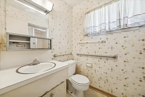a bathroom with a sink a toilet and shower curtain