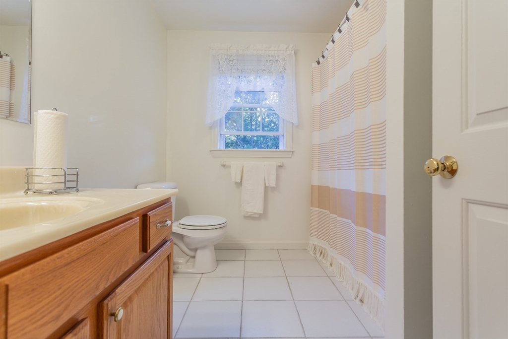 20 Sandy Way Mashpee, MA 02649 - Photo 23 of 33 a bathroom with a granite countertop sink a toilet a mirror and shower