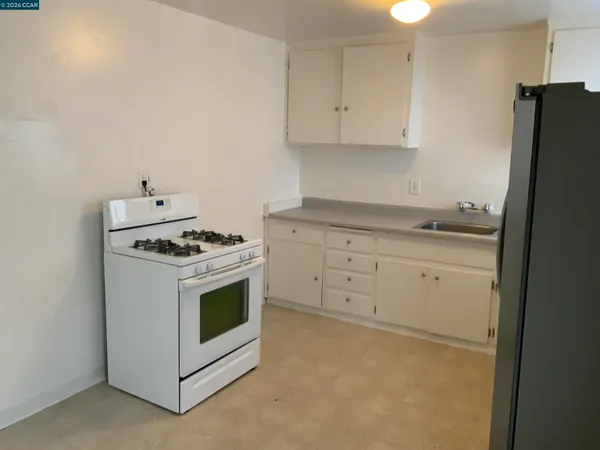 a kitchen with white cabinets and white appliances