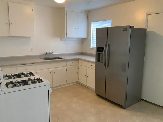 a kitchen with stainless steel appliances a refrigerator stove and sink