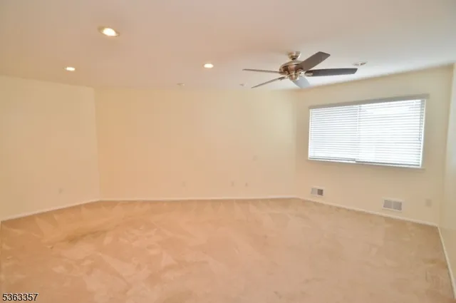 an empty room with a window and a fan