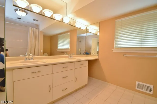 a bathroom with a double vanity sink and a mirror