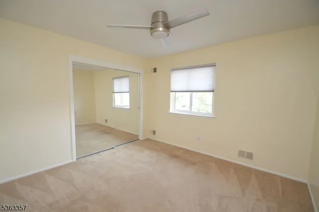 an empty room with windows and cabinet