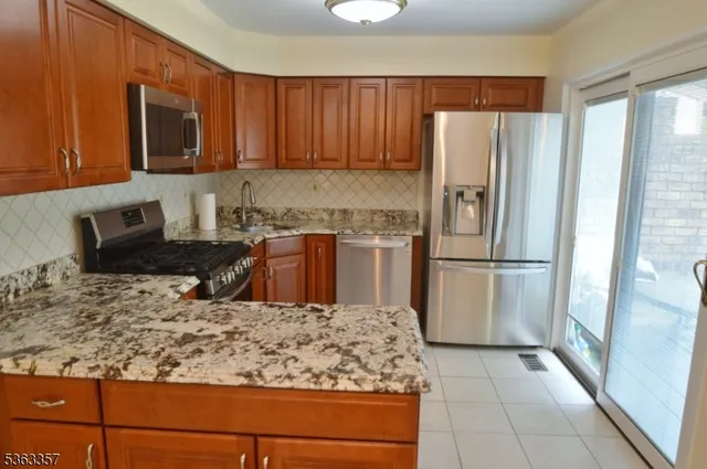 a kitchen with stainless steel appliances granite countertop a refrigerator and a stove