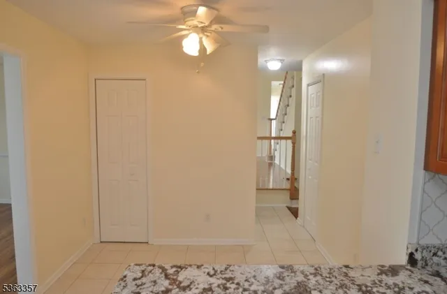 a view of a hallway with wooden floor and a chandelier