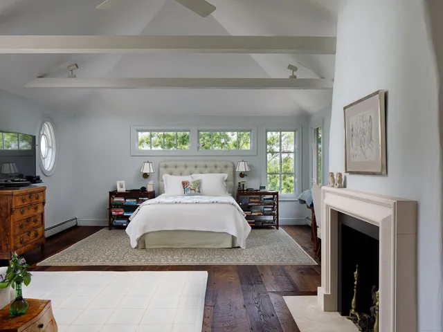 a bedroom with a large bed and a fireplace