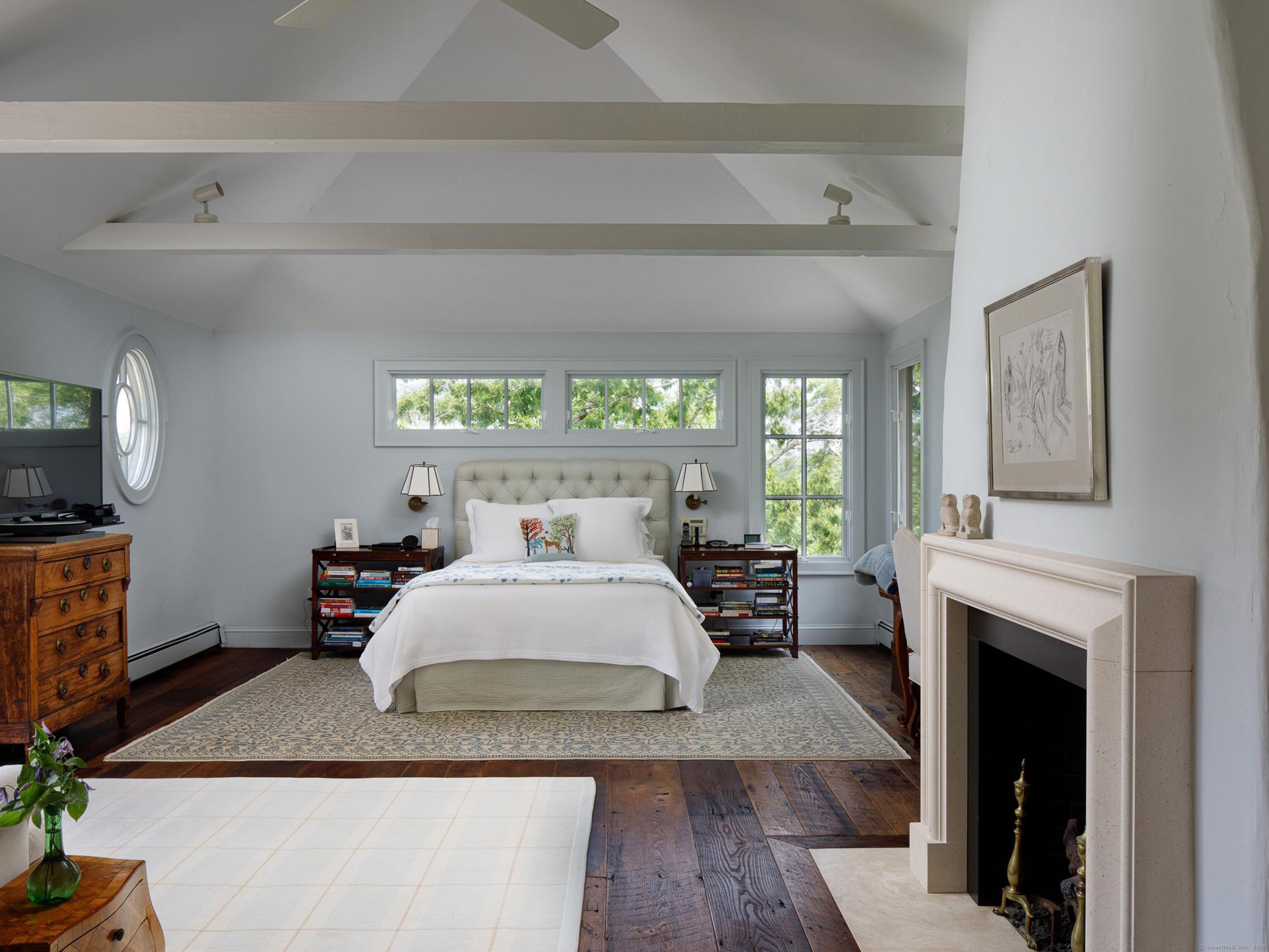 213 Beaver Brook Road Lyme, CT 06371 - Photo 18 of 38 a bedroom with a large bed and a fireplace