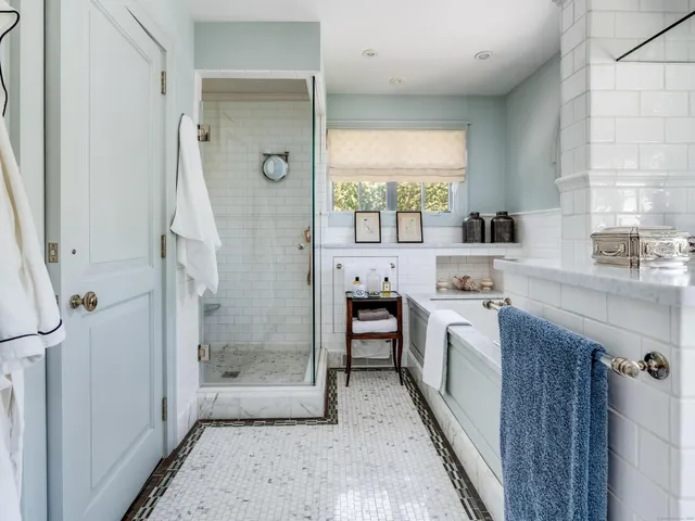 a bathroom with a granite countertop sink a mirror and a bathtub
