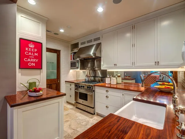 a kitchen with stainless steel appliances granite countertop a stove a sink and a refrigerator