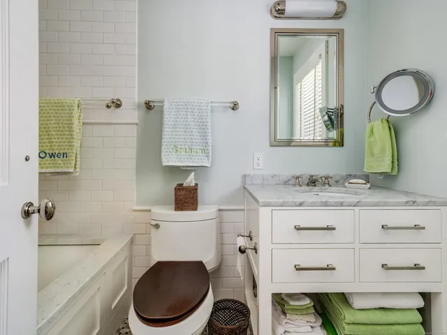 a bathroom with a granite countertop toilet sink and mirror