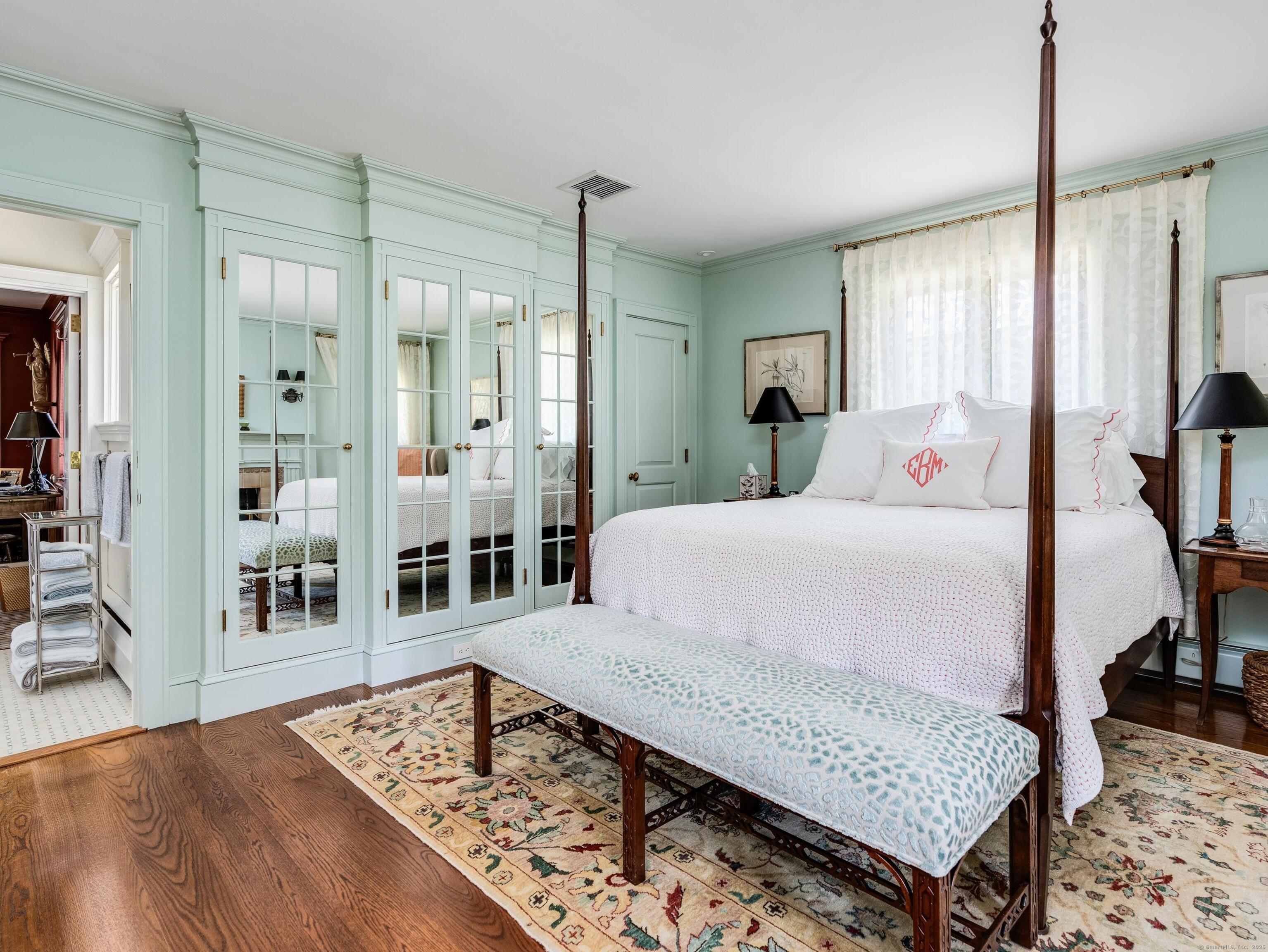 213 Beaver Brook Road Lyme, CT 06371 - Photo 5 of 38 a bedroom with a bed a table and wooden floor