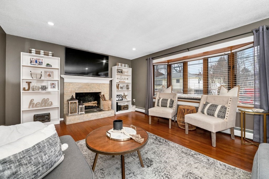 36 Hally Road Lowell, MA 01854 - Photo 3 of 33 a living room with furniture a fireplace and a large window