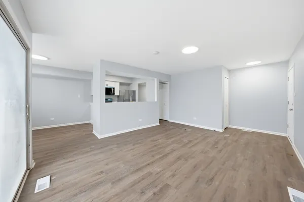 a view of empty room with wooden floor