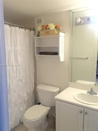 a bathroom with a sink a toilet and shower curtain
