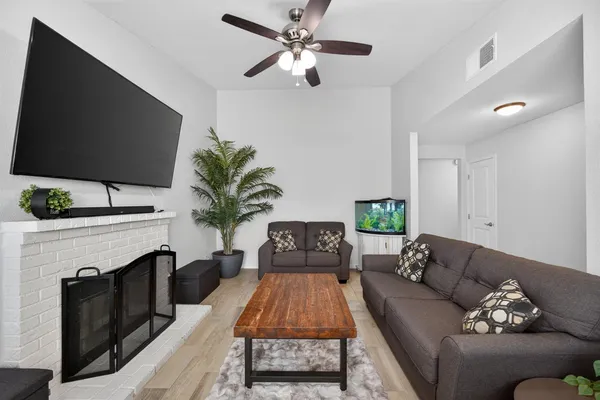 a living room with furniture a fireplace and a flat screen tv