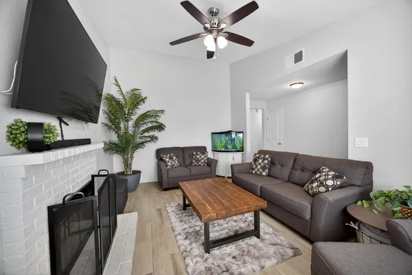 a living room with furniture potted plant and a flat screen tv
