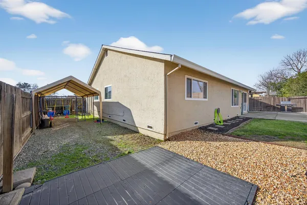 a view of a house with backyard and sitting area